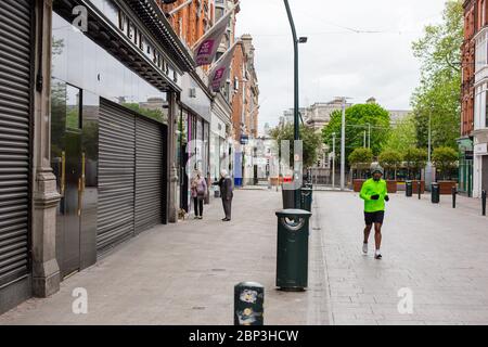 Die Grafton Street im Stadtzentrum von Dublin ist verlassen, da die Geschäfte und Geschäfte geschlossen bleiben und die Einsturzmenge aufgrund der Beschränkung der Coronavirus-Pandemie zurückgegangen ist. Stockfoto