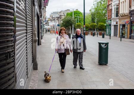 Ältere Paare gehen durch die ruhige Grafton Street im Stadtzentrum von Dublin, da die Geschäfte geschlossen bleiben und die Anzahl der Personen aufgrund einer Coronavirus-Pandemie sinkt. Stockfoto