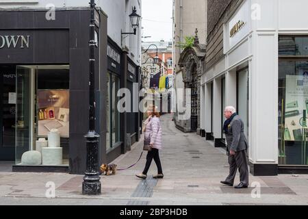 Seniorenpaar, die durch eine ruhige Grafton Street im Stadtzentrum von Dublin gehen, während der Fußabsturz aufgrund einer Coronavirus-Pandemie abstürzt. Civid-19 in Irland. Stockfoto