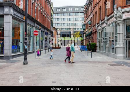 Familienbesichtigung die verlassene Grafton Street im Stadtzentrum von Dublin und ihre geschlossenen Geschäfte, Geschäfte und Pubs sind wegen einer Coronavirus-Pandemie gesperrt. Stockfoto