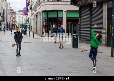 Die Familie spielt auf der verlassenen Grafton Street im Stadtzentrum von Dublin, da Geschäfte und Geschäfte geschlossen bleiben und aufgrund der Covid-19 die Besucherfrequenz sinkt. Stockfoto