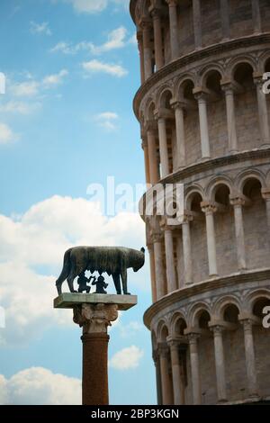 Schiefe Turm mit Kapitolinischen Wölfin (oder Sie - Wolf) Skulptur in Pisa, Italien als die weltweit bekannten Wahrzeichen. Stockfoto