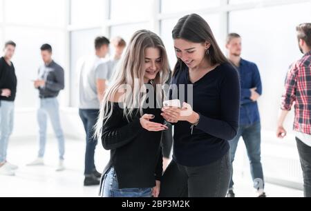 Zwei junge Kollegen schauen auf den Smartphone-Bildschirm Stockfoto