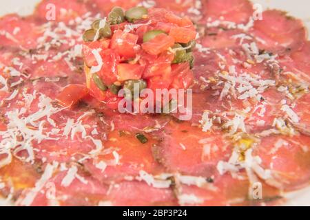 Gericht aus iberischem Rinderfilet Carpaccio mit Tomaten und Olivenöl Stockfoto