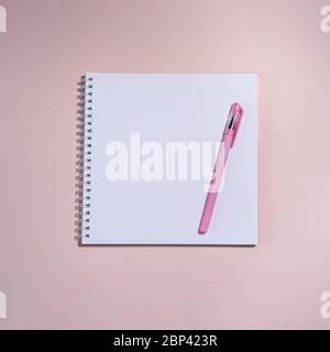 Buch und Stift auf dem rosa Hintergrund geöffnet. Platz für Text. Top im Blick. Stockfoto