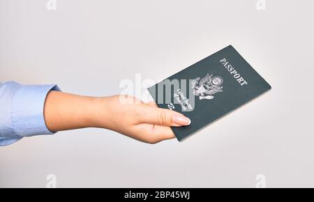 Hand der kaukasischen jungen Frau, die ein passdokument der vereinigten Staaten auf isoliertem weißem Hintergrund hält Stockfoto