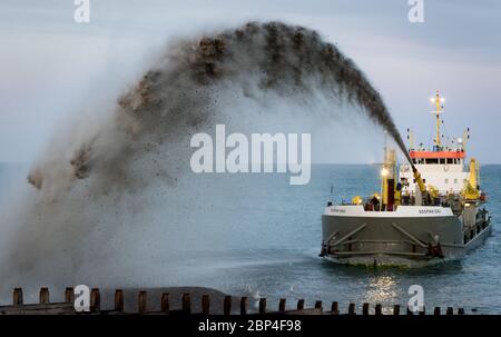 Bagger Sospan Dau pumpt Schindel zurück zum Strand Stockfoto