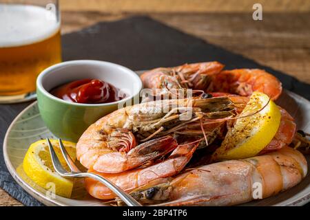 Gedämpfte Garnelen Vorspeise auf Schiefertablett und ein Glas Bier im Hintergrund. Stockfoto