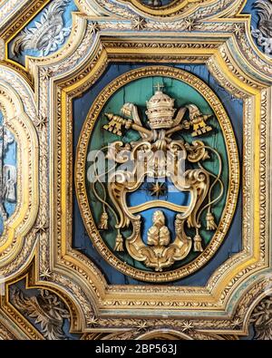 Blick auf das päpstliche Wappen an der Decke in der Basilica di San Clemente, Basilica di Saint Clement, Rom, Italien Stockfoto