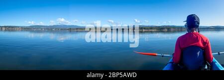 African Australian Frau Kajak auf ruhigen ruhigen See in Morgensonne, Australien Stockfoto