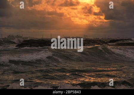 Wellen und starke Winde in der Nacht und der goldene Himmel scheint auf dem Meer von ​​industrial Bereich Stockfoto