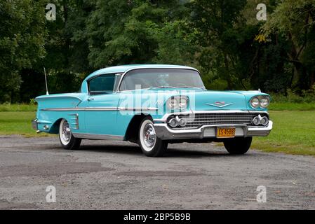 Turquoise 1958 Chevrolet Impala Coupé Dreiviertel-Frontansicht gegen Bäume Stockfoto