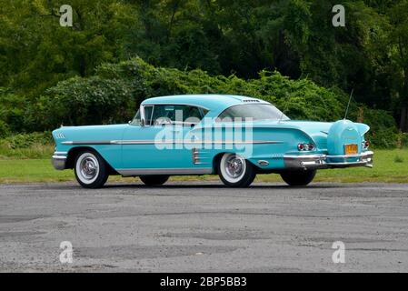 Turquoise 1958 Chevrolet Impala Coupé mit Heckschürze gegen Bäume Heckansicht in Dreiviertelansicht Stockfoto