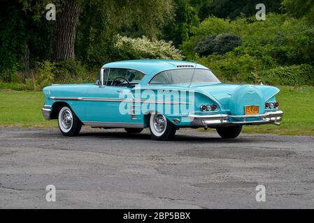 Turquoise 1958 Chevrolet Impala Coupé mit Heckschürze gegen Bäume Heckansicht in Dreiviertelansicht Stockfoto