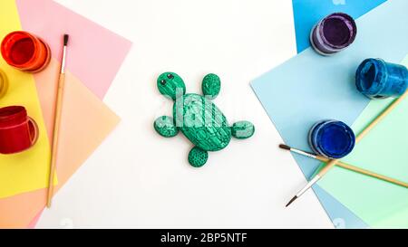 Schritt für Schritt eine Steinschildkröte auf einem Stein malen. Kinder Kunstprojekt. DIY-Konzept. Schritt für Schritt Fotoanleitung.Ansicht von oben. Arbeiten Sie mit Chi Stockfoto
