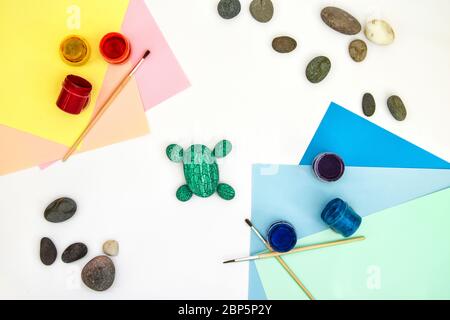 Schritt für Schritt eine Steinschildkröte auf einem Stein malen. Kinder Kunstprojekt. DIY-Konzept. Schritt für Schritt 4 Fotoanleitung.Ansicht von oben. Arbeiten mit c Stockfoto