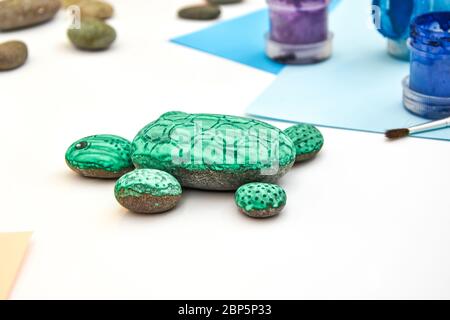 Schritt für Schritt eine Steinschildkröte auf einem Stein malen. Kinder Kunstprojekt. DIY-Konzept. Schritt für Schritt Fotoanleitung.Ansicht von oben. Arbeiten Sie mit Chi Stockfoto