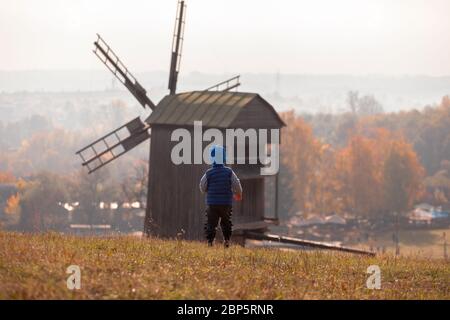 Ein Junge steht auf dem Hintergrund einer alten Mühle im Pirogovo Museum in Kiew, Ukraine Stockfoto