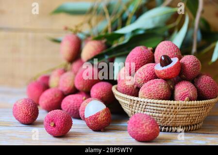 Litschi Scheibe geschält auf Holz / frische Litschi mit grünen Blättern Ernte in Korb von Baum tropische Frucht Sommer in Thailand Stockfoto