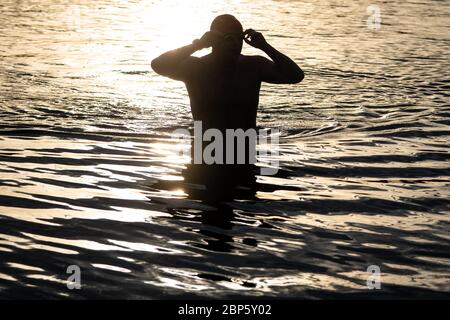 Ein Schwimmer nimmt ein frühes Morgenbad im Serpentine Lido im Hyde Park, London, da es nach der Lockerung der Coronavirus-Lockdown-Maßnahmen für Mitglieder des Serpentine Swimming Club wieder geöffnet wird. Stockfoto