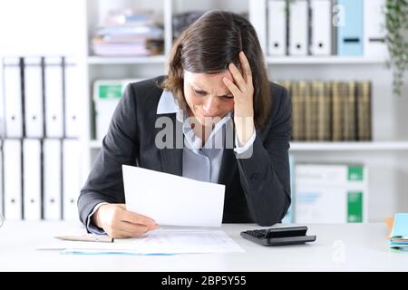 Traurige Dame, die sich über schlechte Ergebnisse beschwert hat, die auf dem Schreibtisch im Büro sitzt Stockfoto