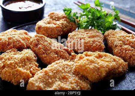 HireKatsu, japanisches Schweinefleisch auf schwarzem Teller mit leckerer Miso-Sauce in einer Schüssel auf einer Bambusmatte, horizontale Ansicht von oben Stockfoto