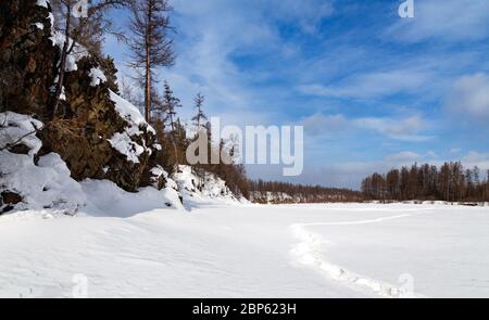 Winterlandschaft des Tschulman-Flusstal in Süd-Jakutien, Russland. Fußspuren im Schnee. Stockfoto