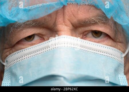 Nahaufnahme Porträt von traurigen Senior Erwachsenen in chirurgischen Gesichtsmaske mit Ohrbändern gekleidet, Abdeckung Nase von SARS, virulently Infektionskrankheit Virus Stockfoto