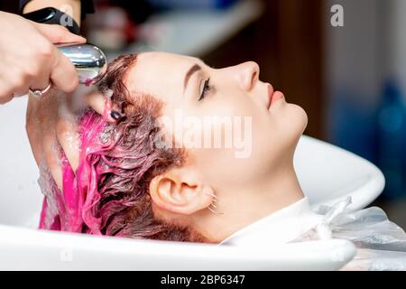 Nahaufnahme der jungen Frau mit ihren farbigen Haaren in einem Schönheitssalon gewaschen. Stockfoto