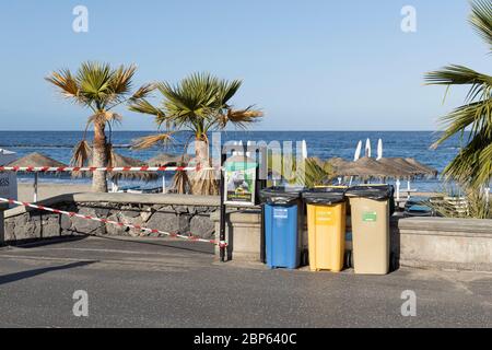 Recycling-Mülltonnen auf dem Gehweg neben einem abgeklebten Zugang zum Strand Playa Fanabe während der ersten Phase der Deeskalation des Covid 19, Coronavirus, Stockfoto