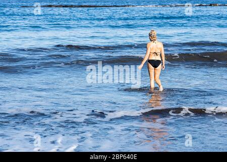 Frau geht in der ersten Phase der Deeskalation des Covid 19, Coronavirus, Notstand, Fanabe, Costa Adeje, ins Meer, um dort illegal zu schwimmen. Stockfoto