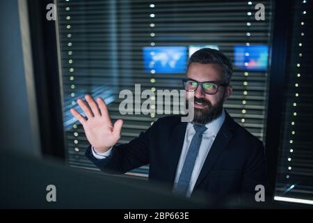 Blick von der Rezeption auf einen Geschäftsmann, der einen Videoanruf mit einem Kollegen an der Rezeption hatte. Stockfoto