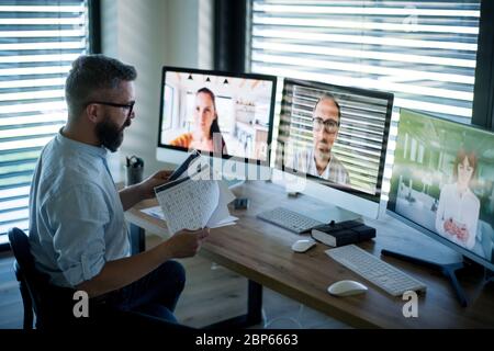 Seitenansicht des Geschäftsmannes, der am Schreibtisch sitzt und einen Videoanruf hat. Stockfoto