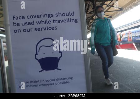 Ein Schild, das Passagiere aufzeigt, am Bahnhof Clapham Junction in London eine Gesichtsmaske zu tragen, da die Zugverbindungen im Zuge der Lockerung der Lockdown-Beschränkungen für Coronavirus zunehmen. Stockfoto