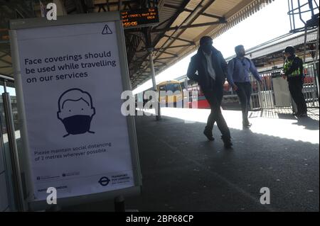 Ein Schild, das Passagiere aufzeigt, am Bahnhof Clapham Junction in London eine Gesichtsmaske zu tragen, da die Zugverbindungen im Zuge der Lockerung der Lockdown-Beschränkungen für Coronavirus zunehmen. Stockfoto