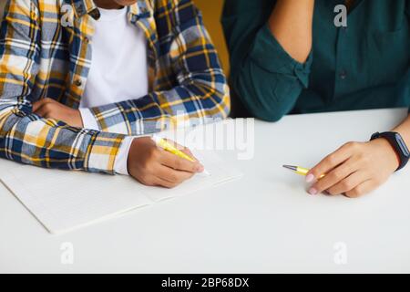 Nahaufnahme eines nicht erkennbaren afroamerikanischen Jungen, der zu Hause studiert, mit Mama, die ihm hilft, Raum kopieren Stockfoto