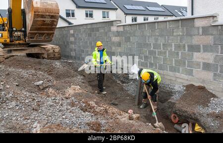 Carrigaline, Cork, Irland. 18. Mai 2020.am ersten Tag der ersten Phase mit der Lockerung der Covid-19-Beschränkungen üben Kyle Power und Patrick Matded soziale Distanzierung bei der Durchführung von Bodenarbeiten auf der Astra-Baustelle in Janeville, Carrigaline, Co. Cork, Irland. - Credit; David Creedon / Alamy Live News Stockfoto