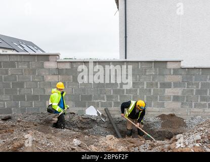 Carrigaline, Cork, Irland. 18. Mai 2020.am ersten Tag der ersten Phase mit der Lockerung der Covid-19-Beschränkungen üben Kyle Power und Patrick Matded soziale Distanzierung bei der Durchführung von Bodenarbeiten auf der Astra-Baustelle in Janeville, Carrigaline, Co. Cork, Irland. - Credit; David Creedon / Alamy Live News Stockfoto