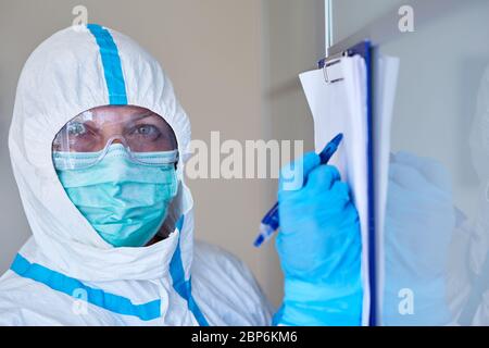 Containment Scout oder Pflegepersonal mit Besucherliste oder Kontaktverfolgung aufgrund von Coronavirus-Pandemie in Klinik oder Pflegeheim Stockfoto