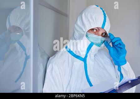 Containment Scout oder Pflegepersonal in Schutzkleidung mit Besucherliste oder Kontaktverfolgung aufgrund von Coronavirus-Pandemie Stockfoto