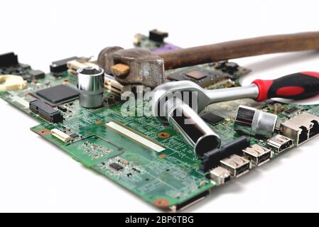 Alter Hammer und Schraubenschlüssel auf einem alten Mikrokreis für einen Computer auf weißem Hintergrund, Nahaufnahme Stockfoto
