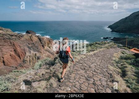 Frau läuft quer durch Land auf einem Pfad in Bergpfad auf der Kanarischen Insel. Meerblick Stockfoto