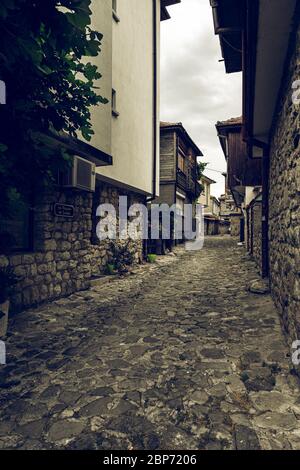 NESSEBAR, BULGARIEN - 22. JUNI 2019: Schöne und schmale Straße der alten Küstenstadt. Verlassene Straßen am frühen Morgen. Tonung. Vintage-Stil. Stockfoto