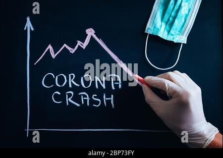 CORONA CRASH, weißer Text mit Kreide auf schwarzem Schulbrett geschrieben, zeigt Grafik Rückgang der Wirtschaft, Zusammenbruch des Finanzmarktes. Schwarzer Bearbeitungsbereich Stockfoto