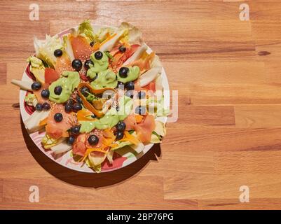 Geräucherter Lachs mit Eissalat, Sellerie, Kirschtomaten, schwarzen Oliven und Sesamsamen Stockfoto