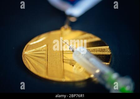 Goldmedaille und Spritze. Doping und Drogen im Sport, Konzeptfoto. Schwarzer Hintergrund Stockfoto