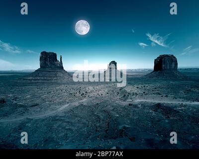 Nacht und Mond über Monument Valley mit roter Wüste. Monument Valley in Arizona mit West Mitten Butte, East Mitten Butte und Merrick Butte. Stockfoto