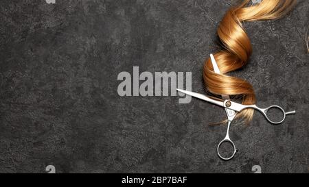 Der Friseur. Schere und Locken der Haare auf schwarzem Hintergrund. Stockfoto