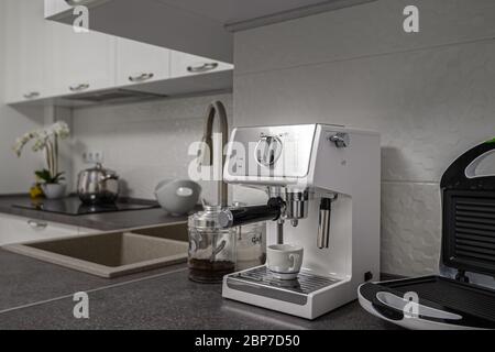 Espressomaschine in minimalistischer weißer Kücheneinrichtung Stockfoto