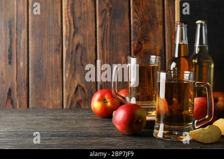 Komposition mit Apfelwein und Äpfeln auf Holzhintergrund Stockfoto